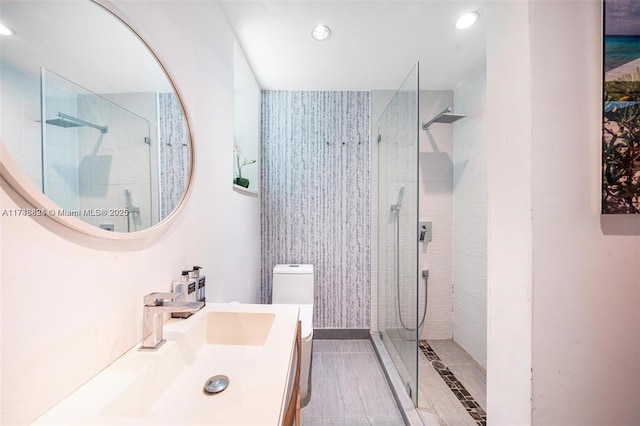 bathroom featuring recessed lighting, toilet, walk in shower, and vanity