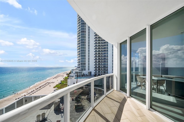 balcony featuring a water view and a view of the beach