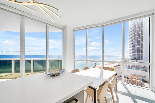 sunroom featuring a water view and a view of the beach