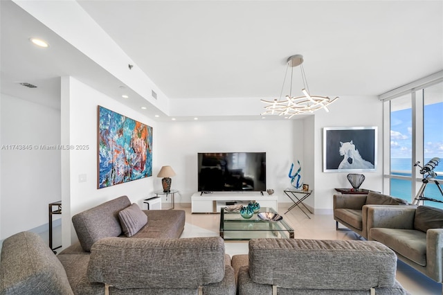 living room featuring a chandelier, expansive windows, visible vents, and recessed lighting