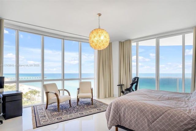 tiled bedroom featuring a water view, multiple windows, and a wall of windows