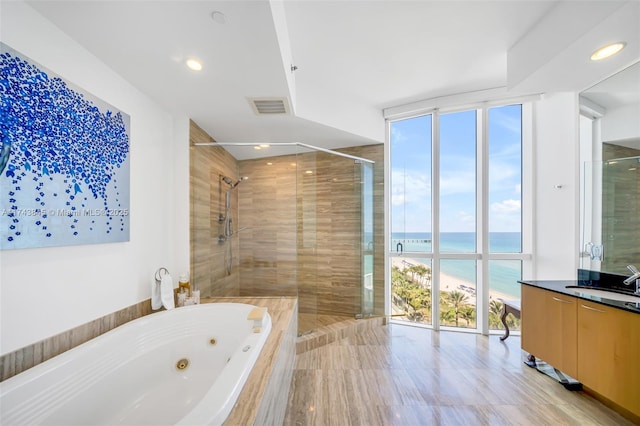 bathroom featuring a stall shower, visible vents, a water view, and a jetted tub