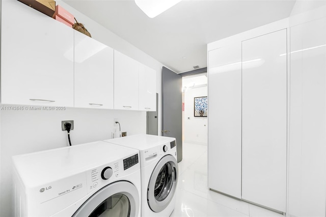 clothes washing area with cabinet space, visible vents, and independent washer and dryer