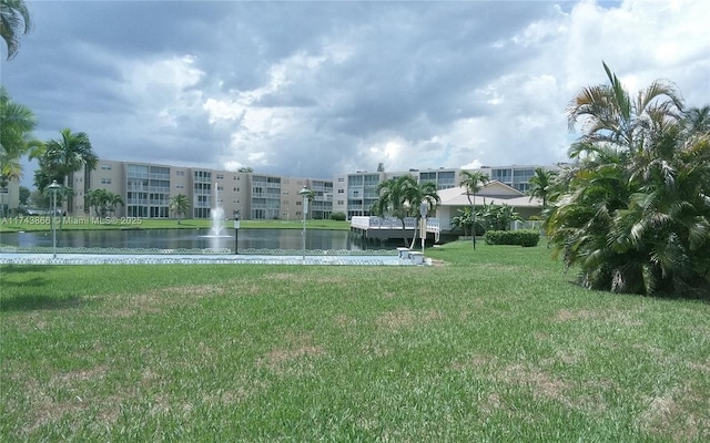 view of community featuring a water view and a lawn