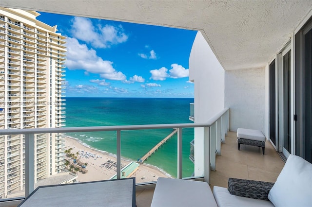 balcony with a water view and a beach view