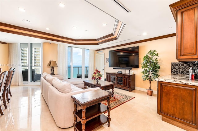 living room featuring a tray ceiling, crown molding, and a healthy amount of sunlight