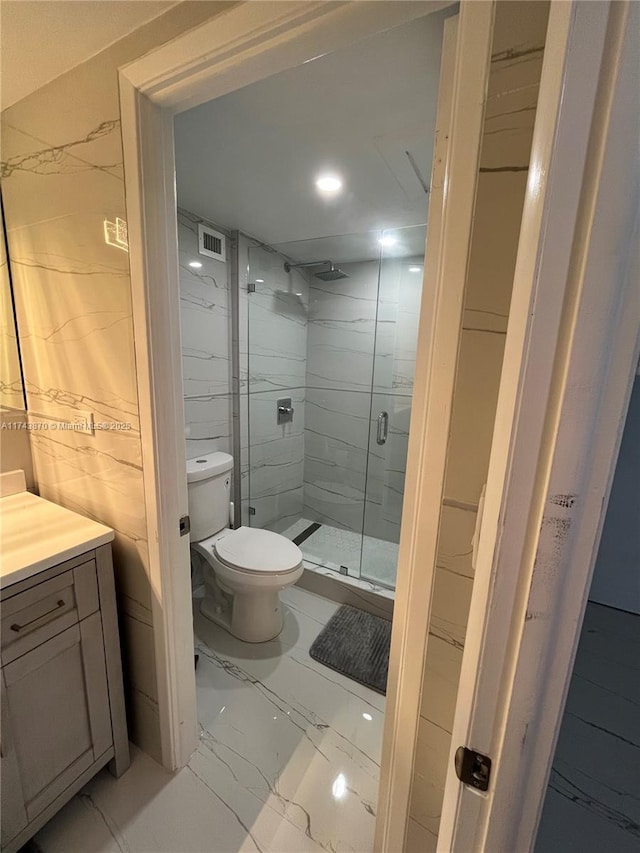 bathroom with vanity, an enclosed shower, and toilet