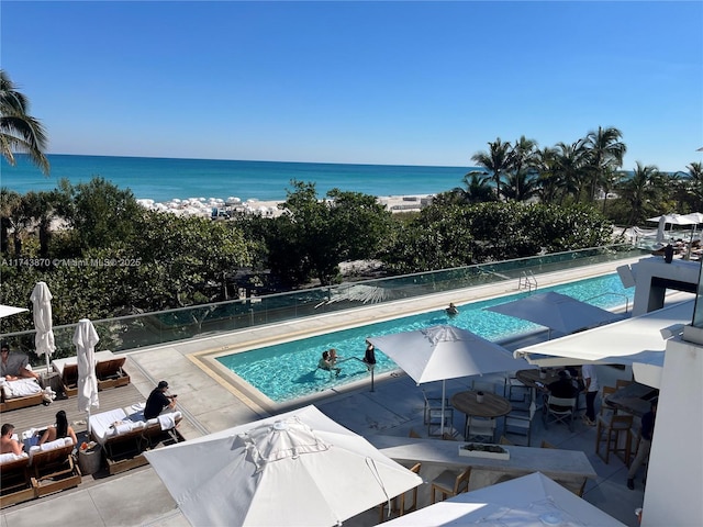 view of swimming pool with a water view and a patio area