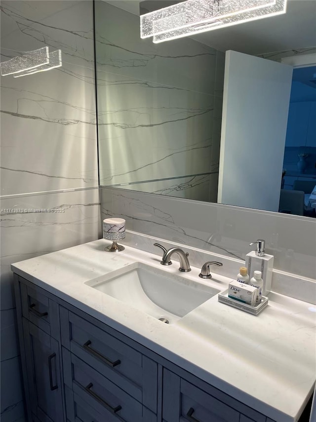 bathroom with vanity and tile walls