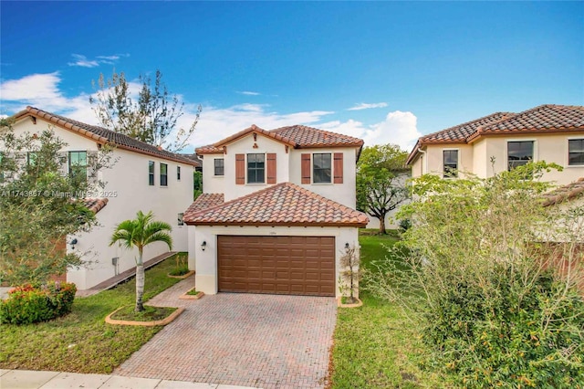 mediterranean / spanish-style house with a garage and a front lawn