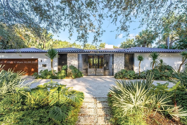 2415 San Domingo St, Coral Gables, FL 33134 - exterior space featuring stone siding, a tile roof, a chimney, and stucco siding