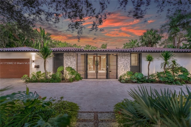2415 San Domingo St, Coral Gables, FL 33134 - exterior space featuring stone siding, a tile roof, decorative driveway, and stucco siding