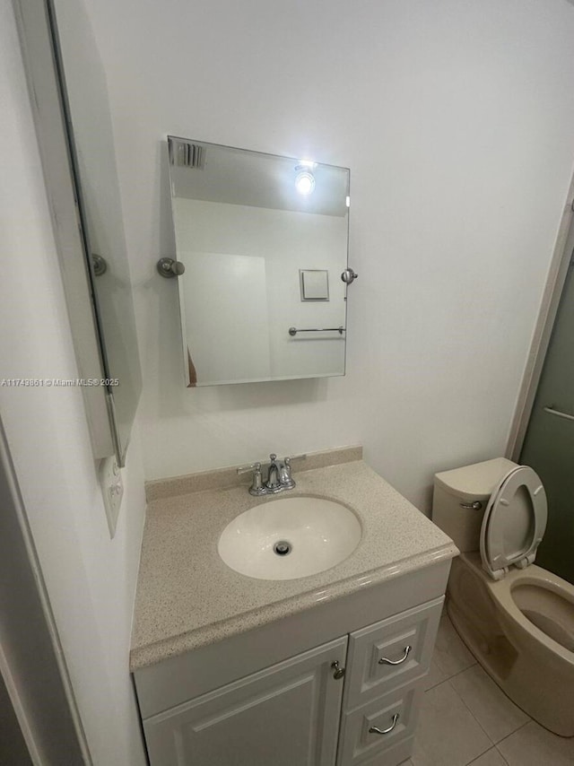 bathroom featuring vanity, toilet, and tile patterned flooring