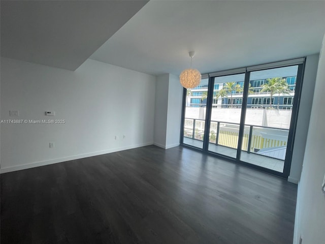 spare room with floor to ceiling windows and dark hardwood / wood-style floors