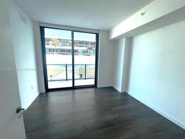 unfurnished room with a wall of windows and dark hardwood / wood-style flooring