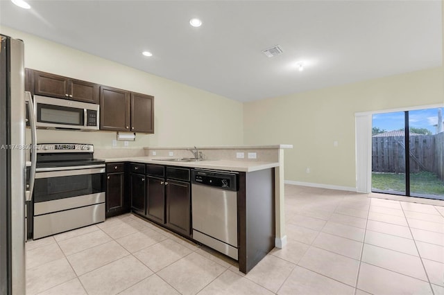 407 SE 32nd Ter, Homestead, FL 33033 - kitchen with light tile patterned flooring, dark brown cabinetry, stainless steel appliances, and sink