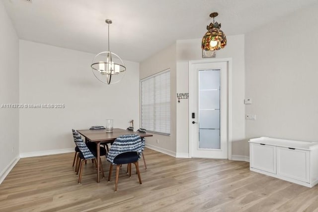 dining space with a notable chandelier and light hardwood / wood-style flooring