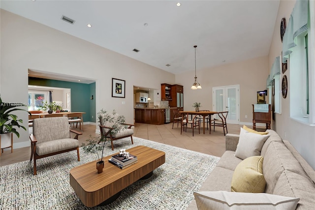 living room with a towering ceiling and light tile patterned floors