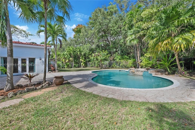 view of pool featuring a yard, a patio area, and french doors