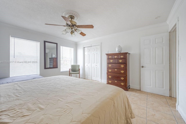 bedroom featuring crown molding, ceiling fan, a textured ceiling, and a closet