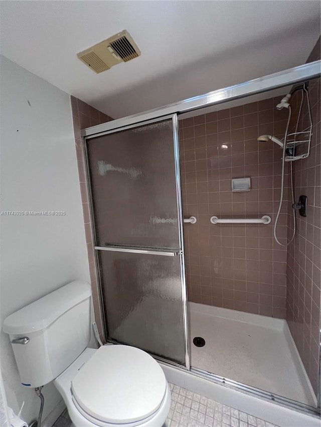 bathroom featuring an enclosed shower and toilet