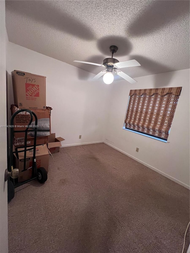 carpeted spare room with a textured ceiling and ceiling fan