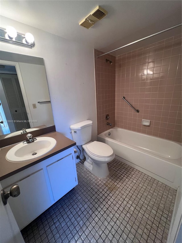 full bathroom with tiled shower / bath, vanity, toilet, and tile patterned flooring