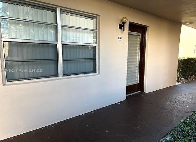 entrance to property featuring stucco siding