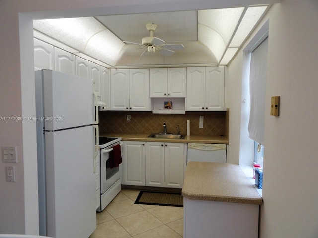 kitchen with white appliances, tasteful backsplash, white cabinetry, and a sink