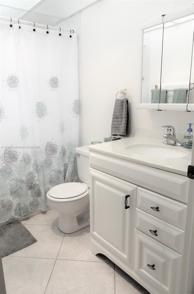 bathroom featuring curtained shower, vanity, toilet, and tile patterned floors