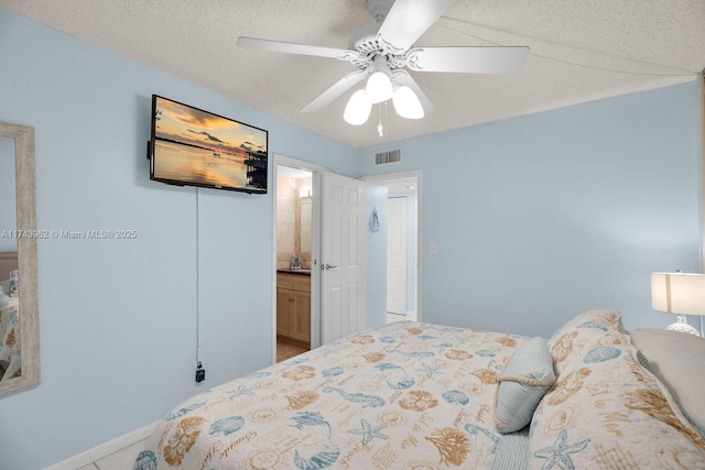 bedroom with ceiling fan, visible vents, a textured ceiling, and ensuite bathroom