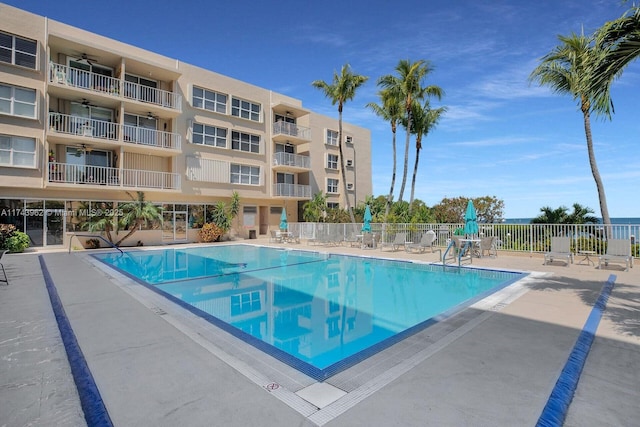 community pool featuring ceiling fan, fence, and a patio