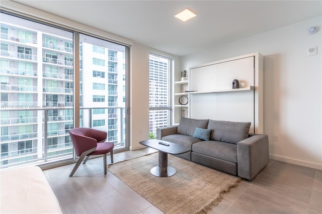 living room with floor to ceiling windows and light tile patterned flooring