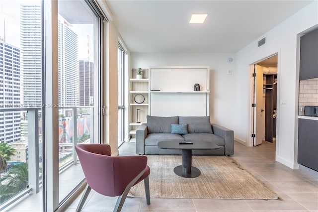 living room with floor to ceiling windows and light tile patterned floors