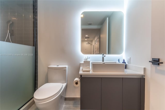 bathroom featuring vanity, an enclosed shower, and toilet