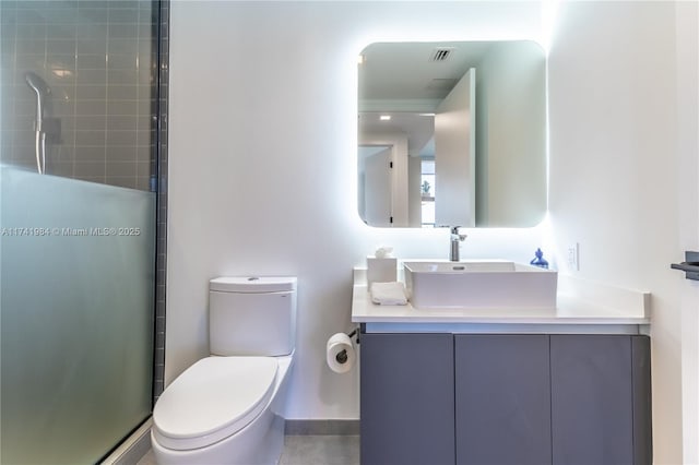 bathroom featuring vanity, toilet, and an enclosed shower