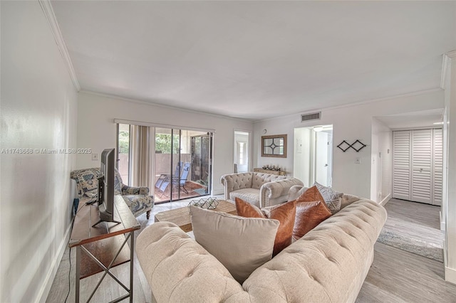 living room featuring ornamental molding and light hardwood / wood-style floors