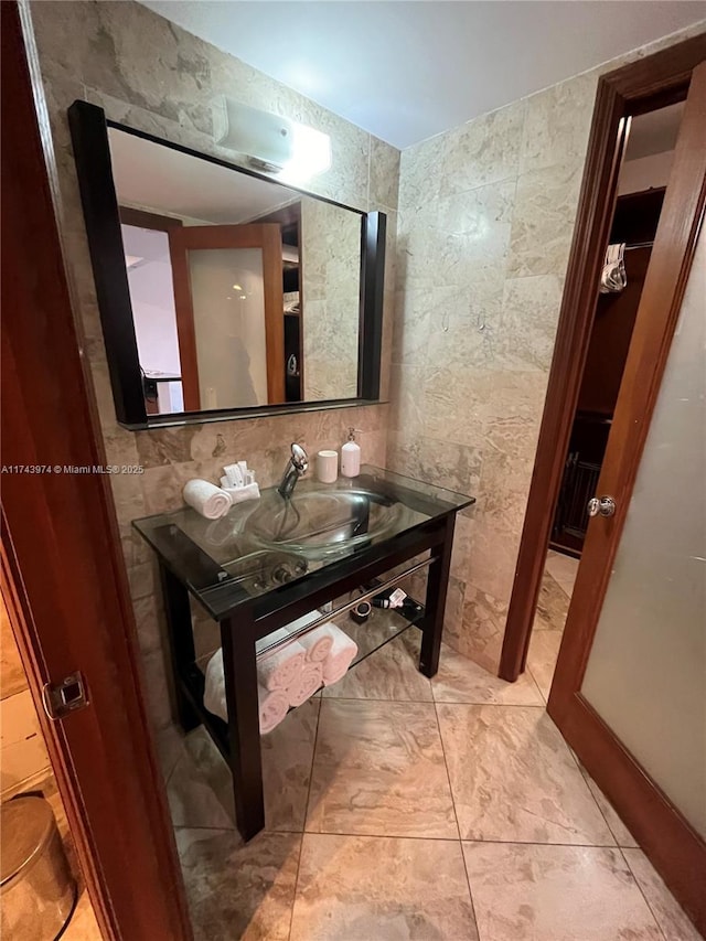 bathroom featuring tile walls and sink