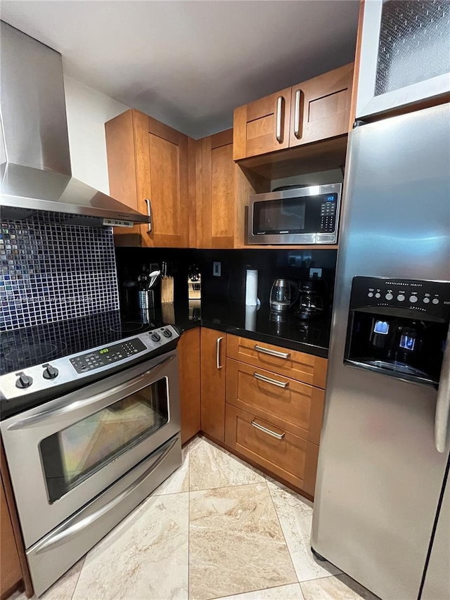 kitchen featuring decorative backsplash, wall chimney exhaust hood, and appliances with stainless steel finishes