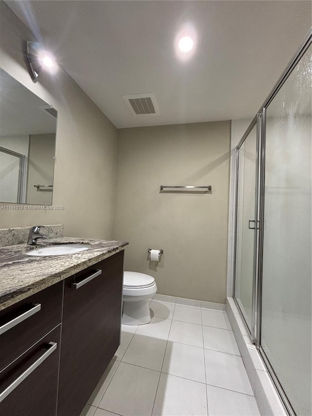 bathroom with walk in shower, vanity, toilet, and tile patterned flooring