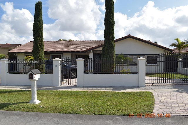 view of front of property with a fenced front yard, a front yard, a gate, and stucco siding