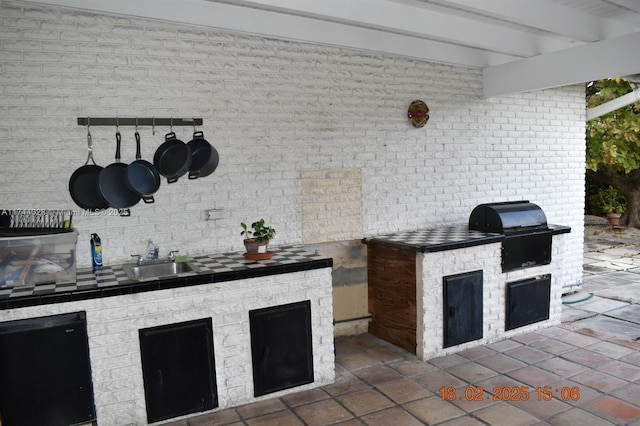 view of patio featuring exterior kitchen, area for grilling, and a sink