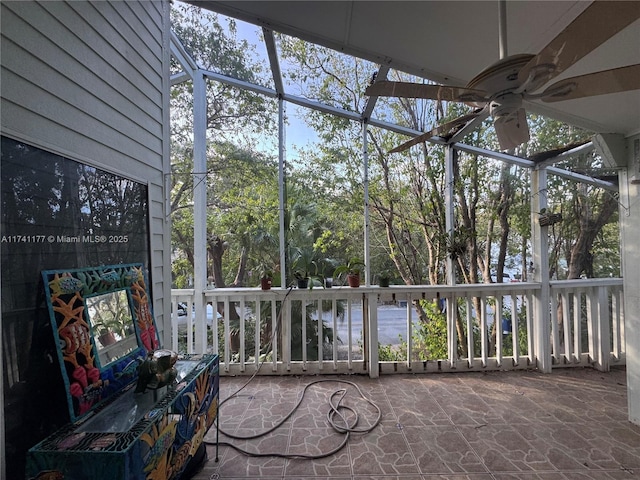 unfurnished sunroom featuring a water view, plenty of natural light, and ceiling fan