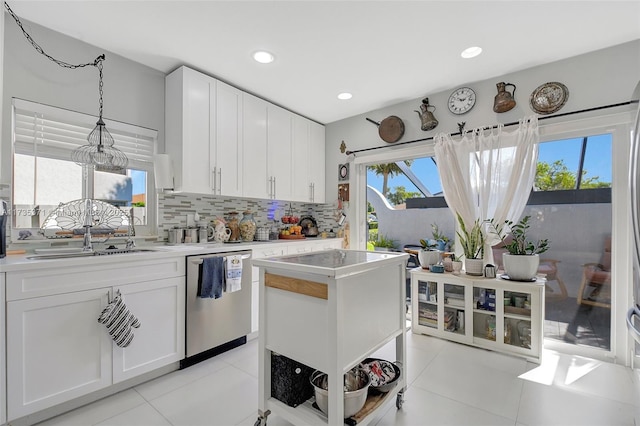 kitchen with white cabinetry, stainless steel dishwasher, sink, and decorative backsplash