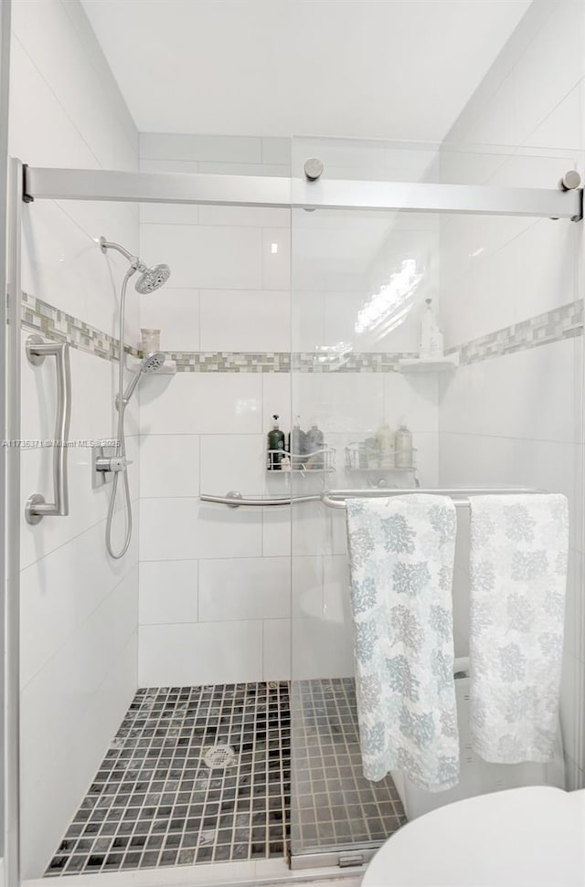 bathroom featuring walk in shower and toilet