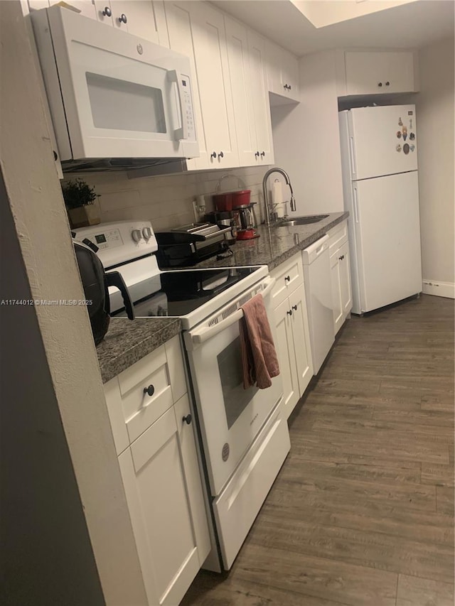 kitchen with sink, white appliances, white cabinetry, dark hardwood / wood-style floors, and tasteful backsplash