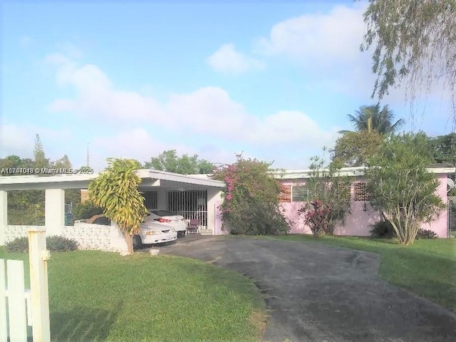 view of front of house with a carport and a front yard