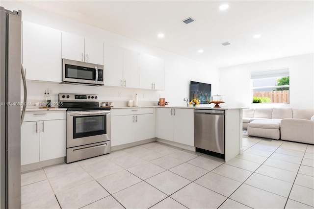 kitchen featuring white cabinetry, kitchen peninsula, and appliances with stainless steel finishes