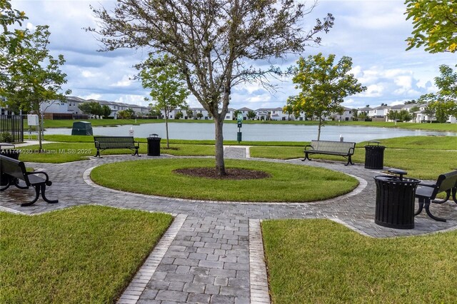 view of community with a water view and a lawn