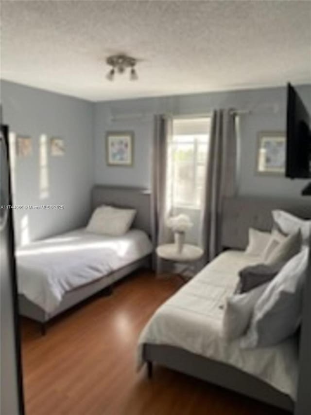 bedroom with dark wood-type flooring and a textured ceiling